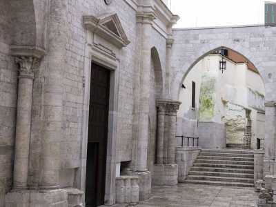 L'altra entrata si apre sul prospetto ovest dell'edificio, vicino a un elegante arco e a una scalinata che un tempo immettevano in un particolare ospedale. Il luogo di ricovero accoglieva infatti guerrieri e religiosi tornati dalla Palestina ammalati o feriti
